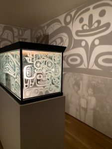 a light box projects shadows of illustrated faces onto the wall