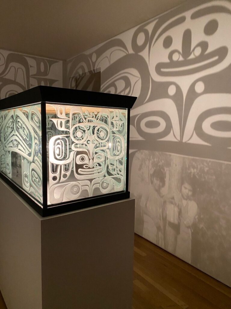 a light box projects shadows of illustrated faces onto the wall