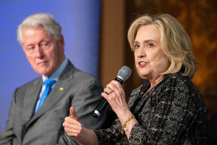 Bill and Hillary Clinton speak at the symposium.