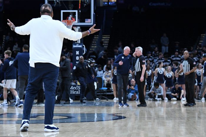 Georgetown men's basketball head coach Ed Cooley stands on the court complaining to the referee