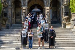 Georgetown faculty and graduate students holding signs on the steps of Healy Hall.