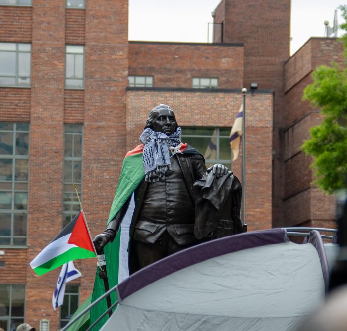 A statue of George Washington holding a Palestinian flag and wearing a keffiyeh.