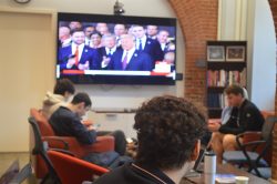 The inauguration plays on a TV screen in the background as a student watches on in the GU Politics Living Room.