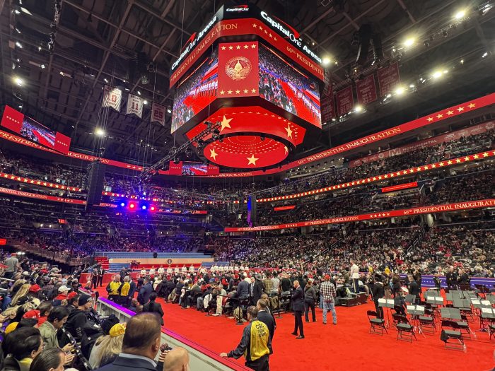 Capital One Arena is pictured. The stadium is packed with supporters, and graphics around the arena read "60th Presidential Inauguration."