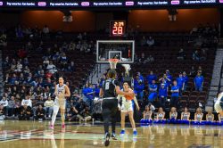 A photo of Khadee Hession taking the ball up the court.