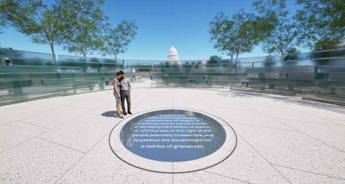 Visitors at the planned memorial look at a black glass circle in the center of the monument. The First Amendment is written in white lettering on the black circle.