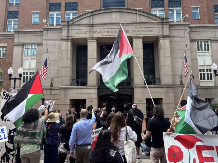 Photo shows demonstrators wearing keffiyehs and waving Palestinian flags outside the Eastern District Court of Virginia