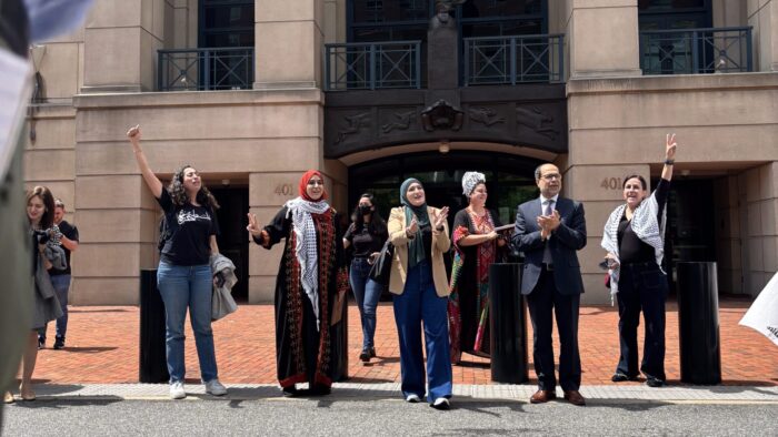 Several individuals stand outside a courthouse with overjoyed expressions