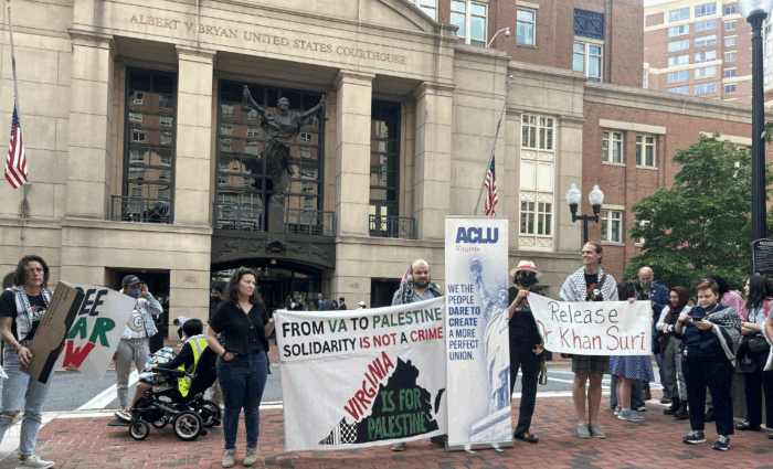 Protesters gather outside the Eastern District Court of Virginia holding up signs in support of Badar Khan Suri.
