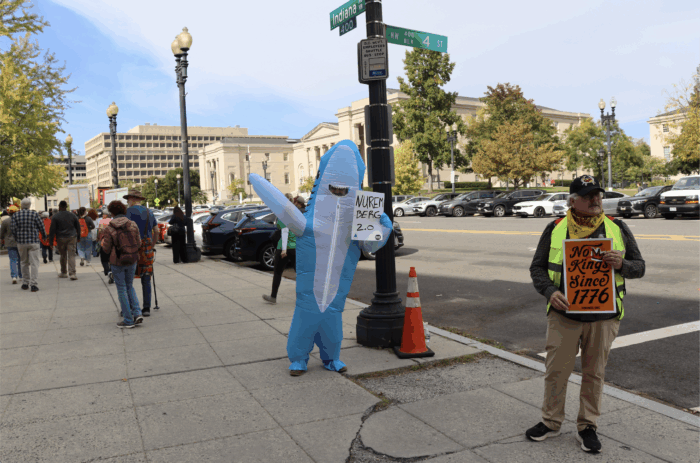 "Chomp Chomp Facism," says one inflatablely dressed protestor