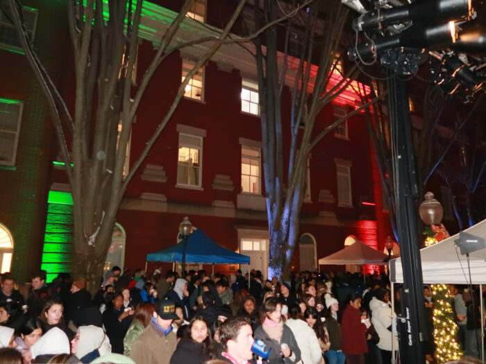 A group of individuals in Dahlgren Quad, near tents with hot drinks.
