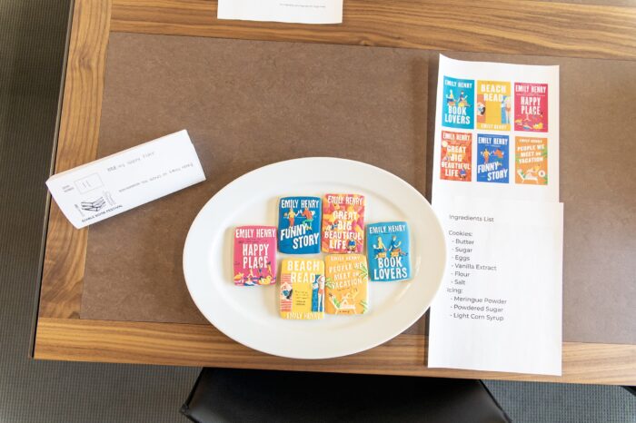 Book-cover inspired cookies next to the source material, on a brown table.