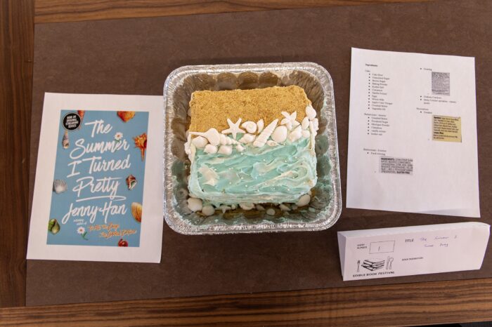 A beach-inspired jello cake, next to the book inspiration on a brown table.